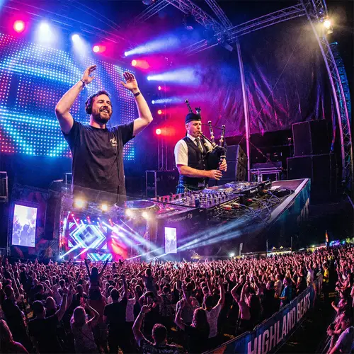 Dynamic EDM Festival Performance with Bagpipe Player