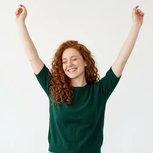 Radiant Redheaded Woman with Raised Arms
