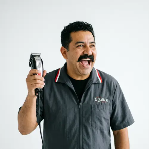 Hispanic Barber Holding Hair Clippers on White Background