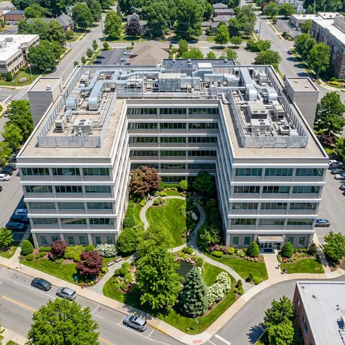 U-Shaped Six-Story Building with Large Windows and Manicured Courtyard