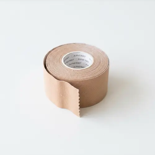 Beige KINESIO Elastic Bandage on White Table