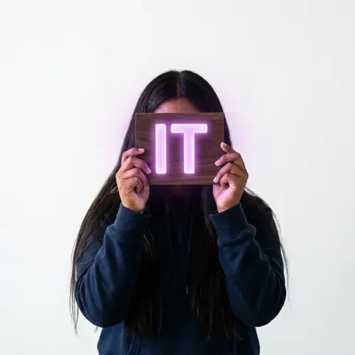 Realistic Teen with Dark Hair Holding Glowing 'IT' Sign