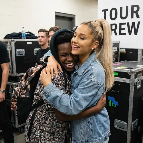 Female Pop Singer Hugging Black Individual with Joy