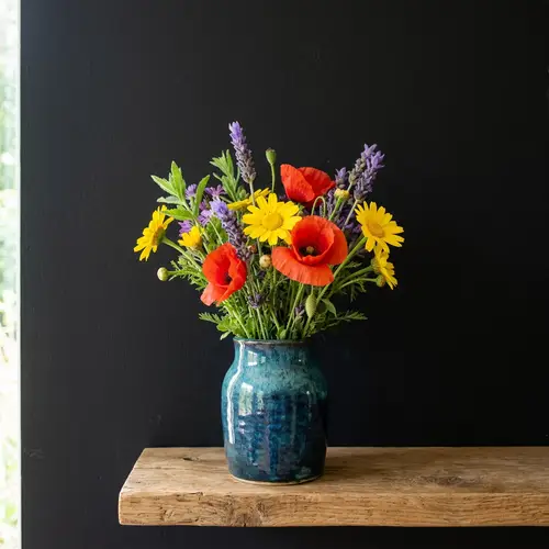 Simple Vase with Vibrant Flowers Against Black Wall