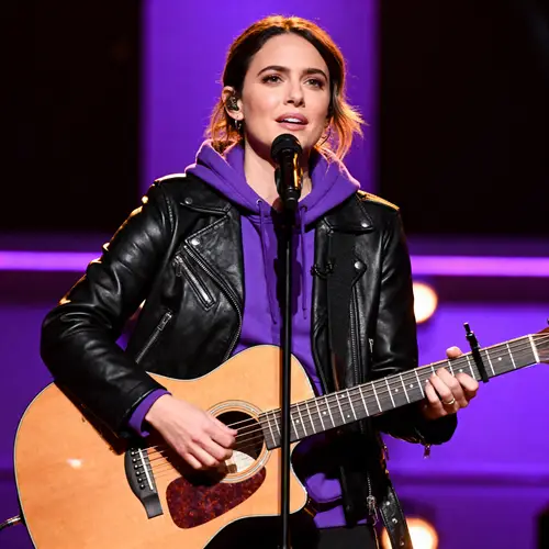 Woman on Stage with Guitar: Leather & Hoodie Style