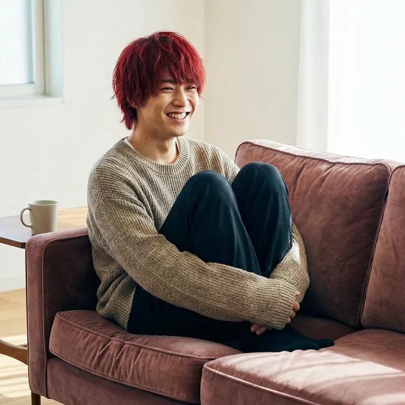 Young Asian Man with Vibrant Red Hair Relaxing on Comfortable Sofa
