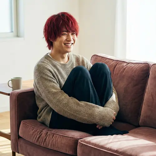 Young Asian Man with Red Hair Relaxing on Sofa