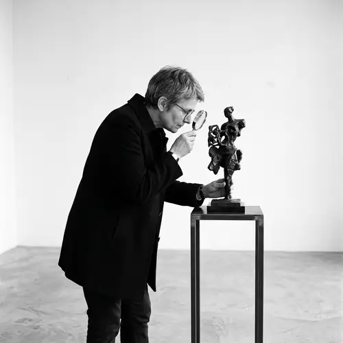 Minimalist Black and White Person Examining Sculpture Art