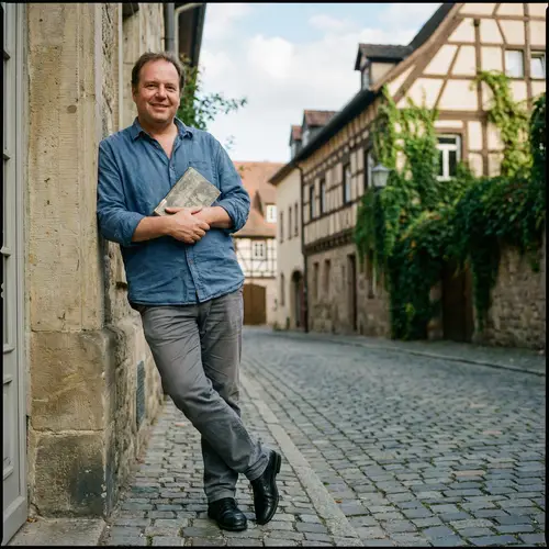 Adult Man in Casual Outfit Standing on Cobblestone Street