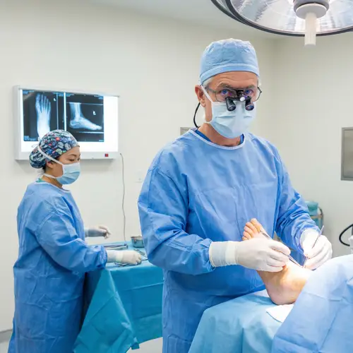 Experienced Caucasian Surgeon Operating on Patient's Foot