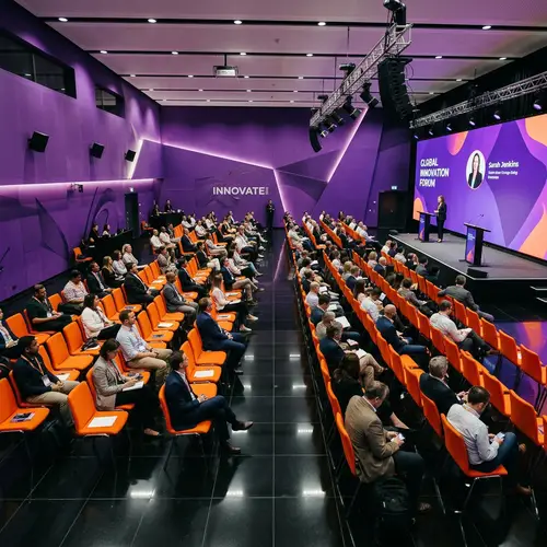 Elegant Conference Hall with Purple Walls & Orange Chairs