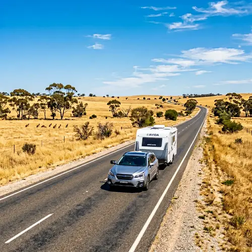 Silver Sedan Towing Modern Caravan on Australian Road