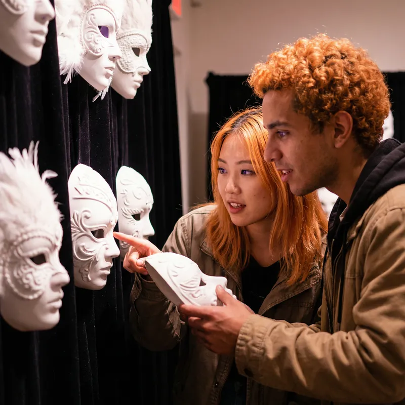 Intricate White Masks: Orange Hair Asian Woman & Hispanic Man