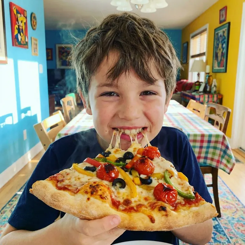 Joyful Boy Eating Delicious Pizza