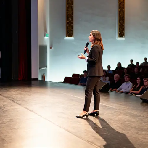 Female Speaker Inspires Audience on Stage