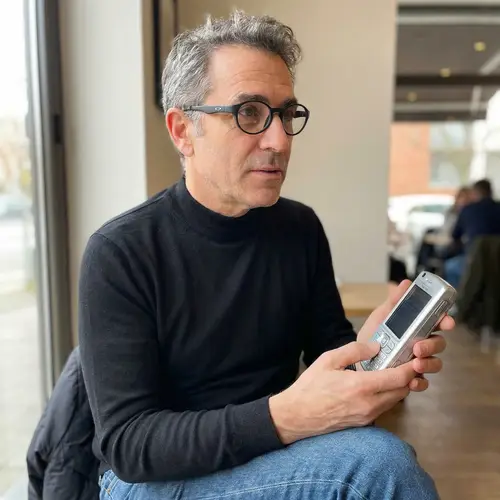 Stylish Man with Salt-and-Pepper Hair and Smartphone Device