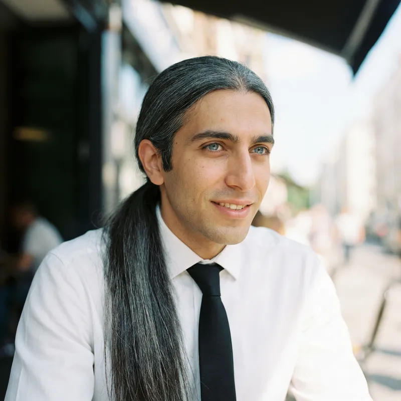 Young Man with Dark Gray Hair in Ponytail and White Shirt