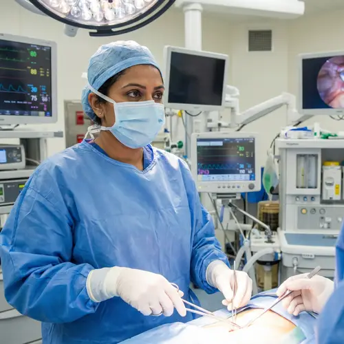 Expert South Asian Female Surgeon in Modern Operating Theatre