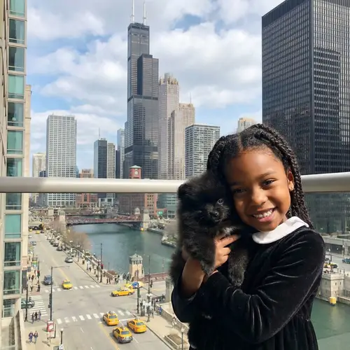 Young African American Girl with Pomeranian Dog in Chicago Skyline