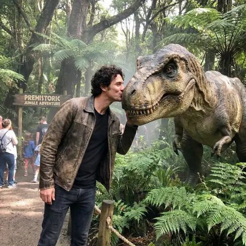 Charismatic Man Kisses Tyrannosaurus Rex in Thrilling Jungle Scene