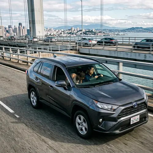 Car Driving Over Bridge with Asian Man and African Woman Inside