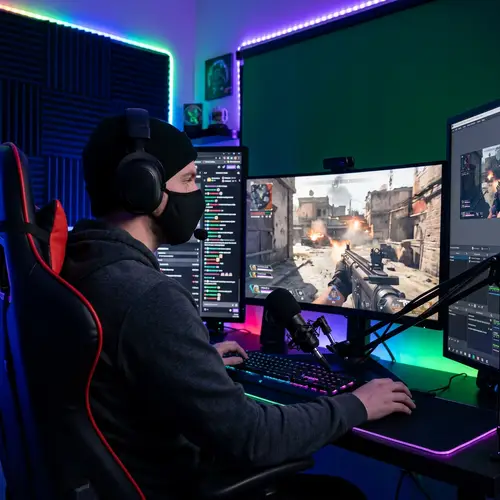 Caucasian Male Streamer Gaming Setup with High-Intensity Virtual Warzone Scene